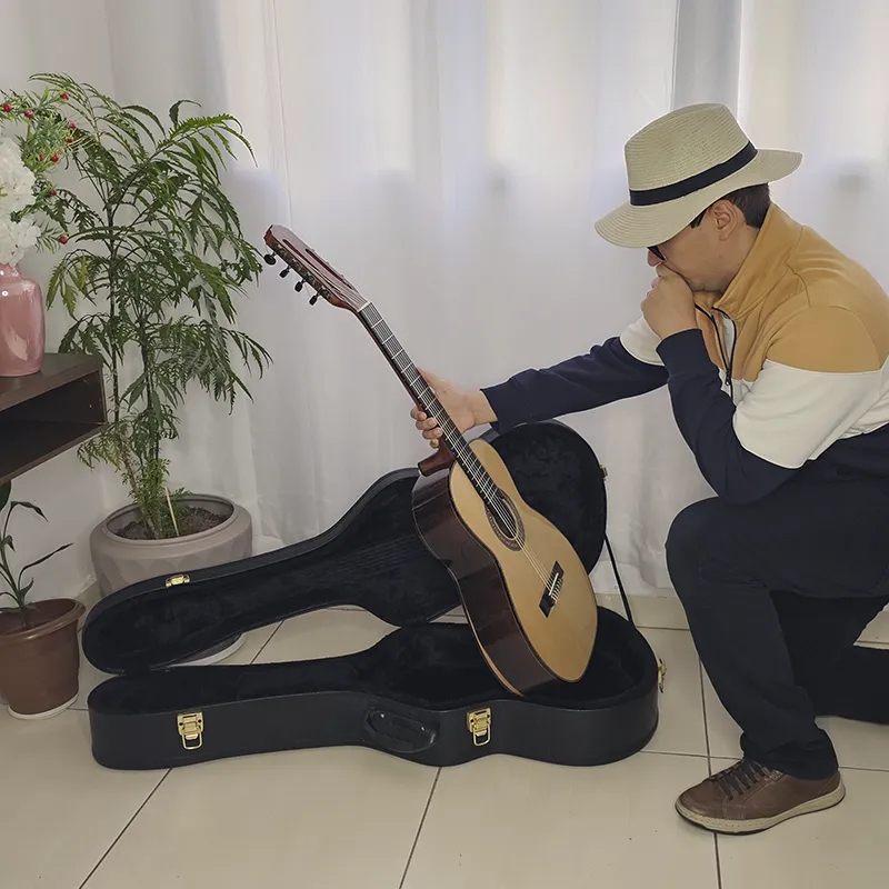 homem verificando o violão antes de guarda-lo