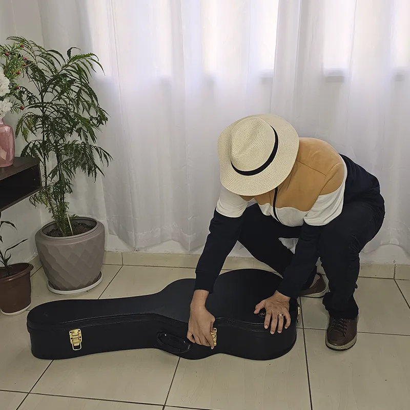 homem quase fechando o violão na case