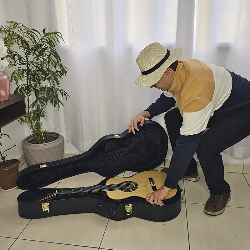 homem indo fechar o case indicando como guardar o violão