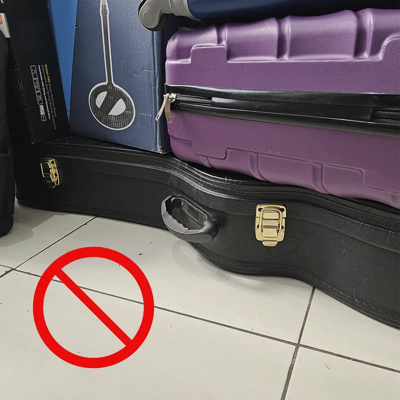 objetos pesados e caixas em cima do estojo (case) do violão