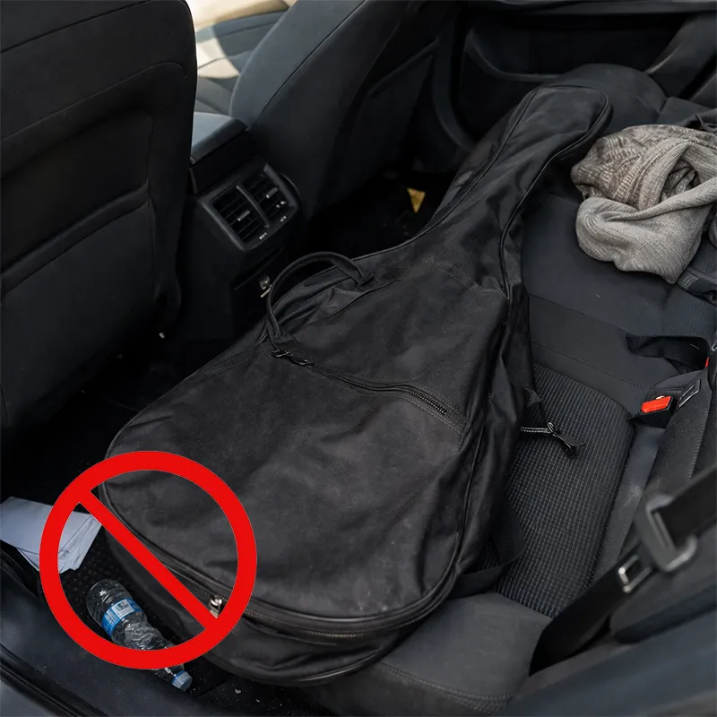 violão dentro de uma capa (bag) colocado no carro de qualquer para transporte