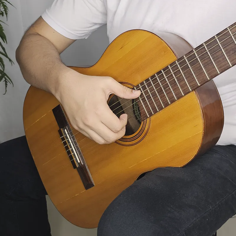 mão direita arqueada sobre as cordas do violão
