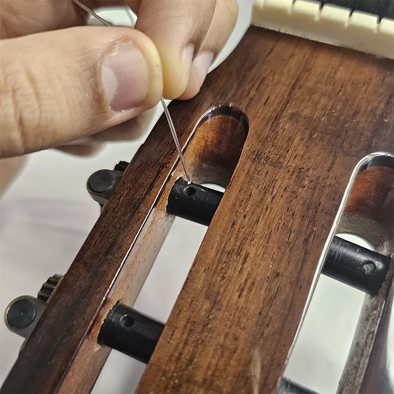 inserindo corda mais aguda no buraco do pino da tarraxa