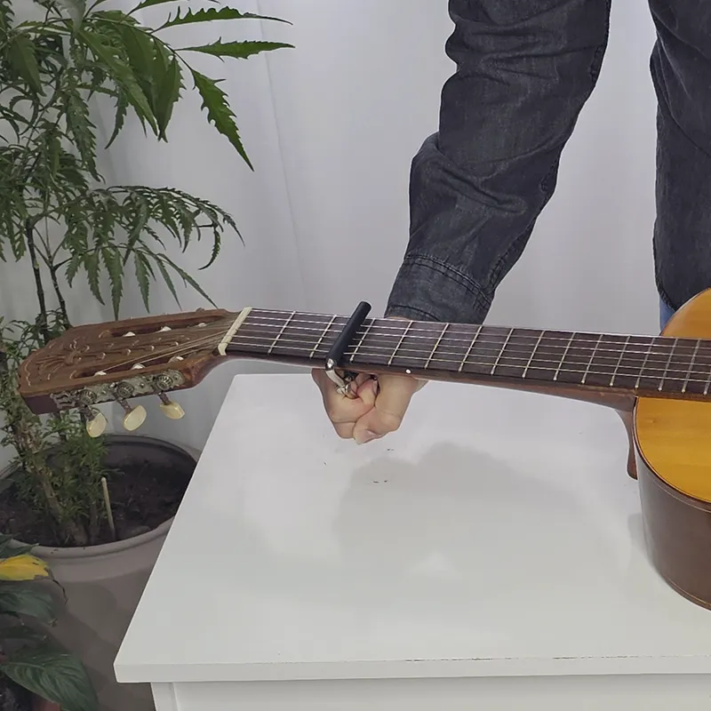 Prendendo o capotraste de metal no braço