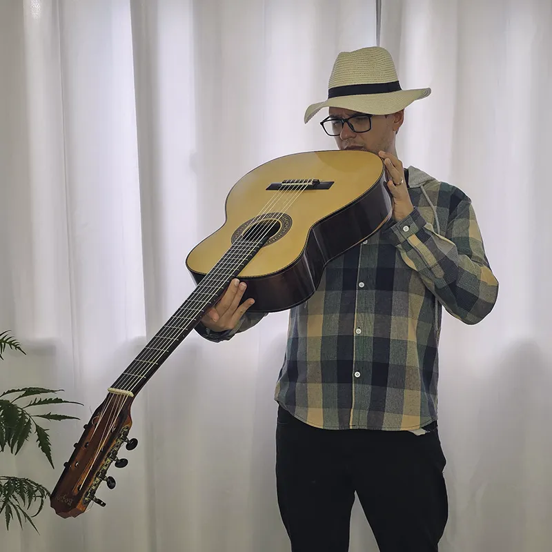 Pessoa inspecionando seu violão olhando rente do corpo para a cabeça