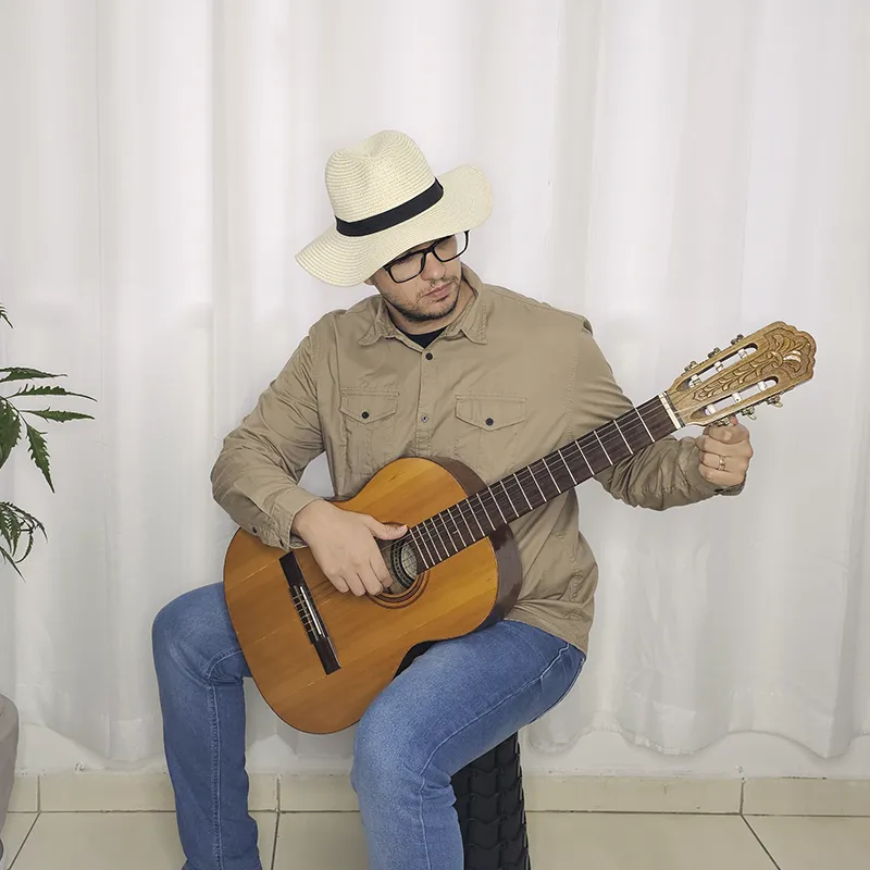 Pessoa conferindo a afinação do violão