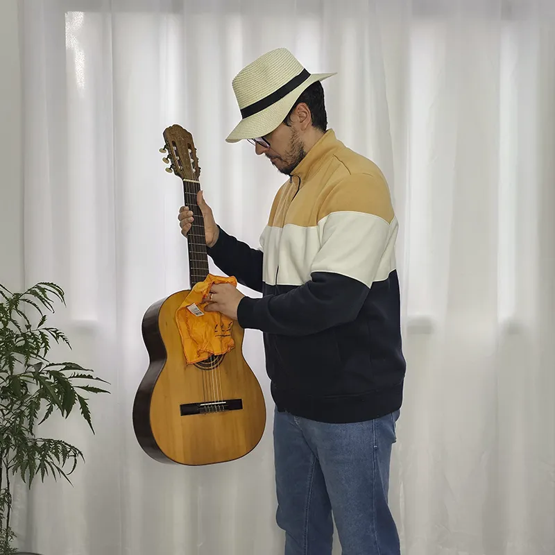Pessoa limpando o violão com uma flanela