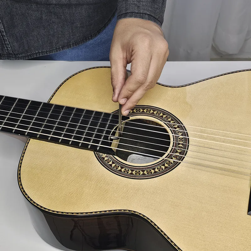 Pessoa mexendo no tensor do violão